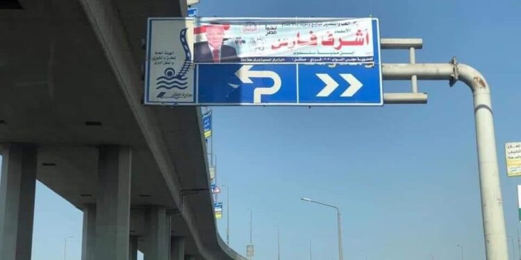 ضاقت بيه الدنيا.. مرشح يستغل لوحة إرشادية بالطريق في الدعاية الانتخابية (التفاصيل)